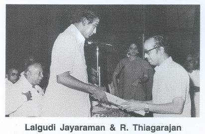 R.Thyagarajan, Treasurer, honouring Lalgudi Jayaraman. Minister Rajaram look on.